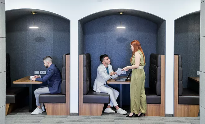 Coworking Space at Qubic Square with clients working and collaborating in an open hot desk area.